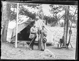 John and Mary Marks with surveying equipment outside a canvas tent