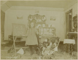 A young girl teaches the alphabet to her toy dolls