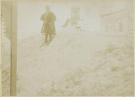 Ella Foote uses wooden skis to cross a snow drift on Main Street, Breckenridge, circa 1899