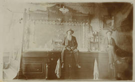 L.C. Whipple and William McManus sit on the bar in the Corner Saloon