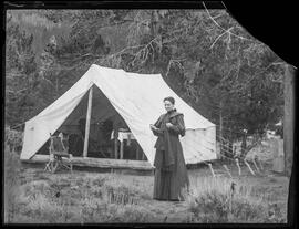 Kate Schwalbach stands outside a canvas platform tent