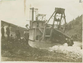 Men watch Colorado II dredge operating on the Swan River near Breckenridge