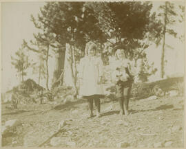 A boy and girl stand outside to pose for a picture