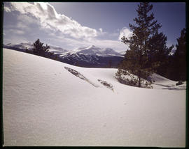 Snowshoes in the snow with a view of Breckenridge ski area