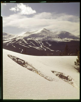 Snowshoes in snow with view of Breckenridge ski area