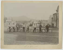 Men pose with decorated bicycles on Main Street, Breckenridge